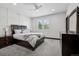 Bright bedroom features a ceiling fan, large window, and a stylish headboard with matching bedside tables and dresser at 5665 Vistancia Ct, Parker, CO 80134