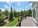 An expansive deck overlooks a landscaped yard with mature trees, a rock waterfall, and inviting outdoor spaces at 5665 Vistancia Ct, Parker, CO 80134