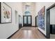 This spacious foyer features a high ceiling, wood-look floors, statement art, and stylish lighting at 5665 Vistancia Ct, Parker, CO 80134