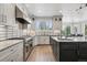Modern kitchen with white cabinets, stainless steel appliances, and center island with marble countertop at 5665 Vistancia Ct, Parker, CO 80134