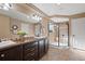 Elegant bathroom featuring double sinks, dark cabinets, tiled floors, and a glass-enclosed shower with a bench at 3395 Starry Night Loop, Castle Rock, CO 80109