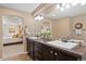 Stylish bathroom featuring double sinks, dark wood cabinets, tiled floors, and seamless access to the bedroom at 3395 Starry Night Loop, Castle Rock, CO 80109