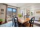 Bright dining room with hardwood floors, sliding glass doors to a patio, and adjacent living room at 3395 Starry Night Loop, Castle Rock, CO 80109