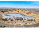 Overhead shot showcasing a clubhouse, pond, and barn, complemented by a scenic backdrop of mountains at 10512 Truckee St, Commerce City, CO 80022