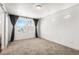 Bright bedroom features large windows and neutral carpeting with stylish barn door entry at 10512 Truckee St, Commerce City, CO 80022