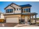 Charming two-story home with tan siding, dark shutters and a covered porch, blending modern and traditional design elements at 10512 Truckee St, Commerce City, CO 80022