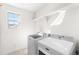 Bright laundry room with modern washer and dryer and practical shelving above at 10512 Truckee St, Commerce City, CO 80022