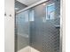 Modern bathroom with a glass shower enclosure featuring blue herringbone tile and sleek fixtures at 10512 Truckee St, Commerce City, CO 80022