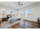 Bright and airy bedroom with hardwood floors and ample natural light from multiple windows at 7169 Canyon Sky Trl, Castle Pines, CO 80108