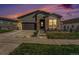 Beautiful home at sunset with stone accents, a well-kept lawn, and concrete driveway at 7169 Canyon Sky Trl, Castle Pines, CO 80108