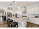 Modern kitchen with white cabinets, granite countertops, stainless steel appliances, and pendant lighting at 7169 Canyon Sky Trl, Castle Pines, CO 80108