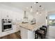 Modern kitchen with granite counters, white cabinets, stainless appliances, and breakfast bar seating at 7169 Canyon Sky Trl, Castle Pines, CO 80108