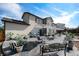 Large backyard with a stone patio featuring dining sets, lounge chairs, and a lush green lawn at 504 Branding Iron Ct, Brighton, CO 80601