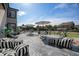 Spacious backyard with a large stone patio featuring dining sets, lounge chairs, and lush green grass at 504 Branding Iron Ct, Brighton, CO 80601