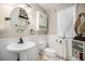Charming bathroom features a pedestal sink, decorative mirror, and framed window at 504 Branding Iron Ct, Brighton, CO 80601