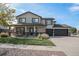 Two-story home featuring manicured lawn, a three car garage, and a charming stone facade at 504 Branding Iron Ct, Brighton, CO 80601