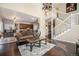 Living room with hardwood floors, elegant stairway, and an open layout leading to the kitchen at 504 Branding Iron Ct, Brighton, CO 80601