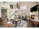 Elegant living room with fireplace, hardwood floors, a staircase, and lots of natural light at 504 Branding Iron Ct, Brighton, CO 80601