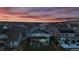 Sunset aerial view of a home showcasing a backyard with a hot tub and outdoor seating against the backdrop of the neighborhood at 690 Avena Dr, Elizabeth, CO 80107