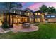 Elegant backyard with a covered patio, comfortable seating, and beautiful landscaping under a colorful evening sky at 4600 E 3Rd Ave, Denver, CO 80220