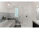 Bright bathroom featuring a soaking tub, marble accents, and modern lighting fixture at 4600 E 3Rd Ave, Denver, CO 80220