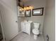Well-lit bathroom features a vanity with storage, a mirror, a toilet, and tile flooring at 12478 W Nevada Pl # 207, Lakewood, CO 80228