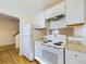 Bright kitchen with white appliances, light countertops, and hardwood floors at 2269 Coronado Pkwy # C, Denver, CO 80229