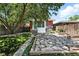 Backyard view featuring stone patio, manicured yard, and mature trees at 2660 Julian St, Denver, CO 80211