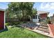 Spacious backyard featuring a lush lawn, mature tree, and a stone patio at 2660 Julian St, Denver, CO 80211