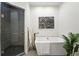 Bright bathroom showcasing a sleek soaking tub and glass-enclosed shower at 2660 Julian St, Denver, CO 80211