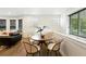 Bright dining area with round wood table, seating for four, and natural light from the windows at 2660 Julian St, Denver, CO 80211