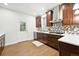 A charming kitchen with white quartz counters, stainless appliances, and wood-look tile floors at 2660 Julian St, Denver, CO 80211