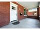 Inviting covered porch featuring a brick facade, white door, and space for outdoor seating at 2660 Julian St, Denver, CO 80211