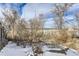 View of backyard with snow-covered ground and trees at 4501 S Lipan Ct, Englewood, CO 80110