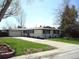 Ranch style home with attached garage and landscaped lawn at 770 S Arbutus St, Lakewood, CO 80228