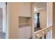 Hallway with built-in storage leading to a bedroom featuring soft carpet and a window at 3706 S Fairplay Way, Aurora, CO 80014