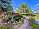 Beautiful backyard pond and garden featuring lush landscaping, stone accents, and wooden bridge at 9466 Morning Glory Ln, Highlands Ranch, CO 80130
