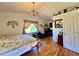 Cozy bedroom with vaulted ceiling, chandelier, hardwood floors, and natural light at 9466 Morning Glory Ln, Highlands Ranch, CO 80130