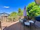 Outdoor deck featuring a table and chairs, surrounded by lovely landscaping and mature trees at 9466 Morning Glory Ln, Highlands Ranch, CO 80130