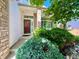 Inviting front entrance with a red door, decorative stone pillar, and lush green landscaping at 9466 Morning Glory Ln, Highlands Ranch, CO 80130
