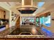 Kitchen island with cooktop and hood vent featuring seating and an open view to the Gathering room at 9466 Morning Glory Ln, Highlands Ranch, CO 80130
