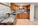 Updated kitchenette with wood cabinets, granite countertops, and a gray tile backsplash at 9466 Morning Glory Ln, Highlands Ranch, CO 80130