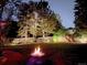 Backyard with a firepit and lush green lawn under a starry night sky at 10991 E Vassar Dr, Aurora, CO 80014