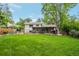 Spacious backyard featuring a large grassy area, mature trees, and a patio at 10991 E Vassar Dr, Aurora, CO 80014