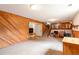 Spacious basement featuring wood-paneled walls, carpeted floors, and a staircase leading to the upper level at 10991 E Vassar Dr, Aurora, CO 80014