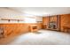 Cozy basement with carpet, wood-paneled walls, a brick fireplace, and shelving at 10991 E Vassar Dr, Aurora, CO 80014