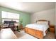 Bright bedroom with a desk, large window, and light green accent wall at 10991 E Vassar Dr, Aurora, CO 80014
