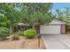 Charming single-story home with lush landscaping, brick accents, and an attached garage at 10991 E Vassar Dr, Aurora, CO 80014