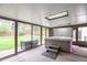 Relaxing hot tub located in enclosed sunroom with backyard views and a convenient storage box at 10991 E Vassar Dr, Aurora, CO 80014