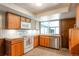 Functional kitchen with wood cabinets, stainless steel appliances, and tiled backsplash at 10991 E Vassar Dr, Aurora, CO 80014